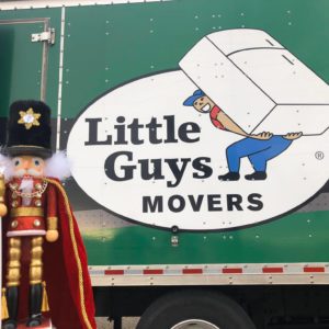 Nutcracker toy in front of Little Guys Movers truck