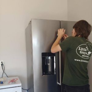 Little Guy reassembling a handle to a fridge