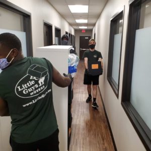 Little Guys Movers employees moving boxes in Grace Like Rain office