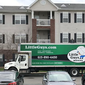 Little Guys Movers apartment moving truck in front of building