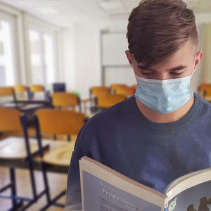 Student wearing mask reading in school