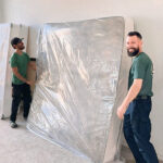 Little Guys Movers in San Antonio move a mattress wrapped in plastic wrap