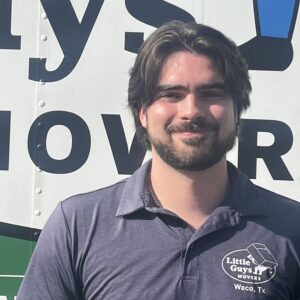 Little Guys Movers in Waco's Branch Manager, Ty, stands in front of a moving truck.