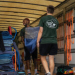 Two Little Guys Movers movers carefully move furniture into the moving truck.