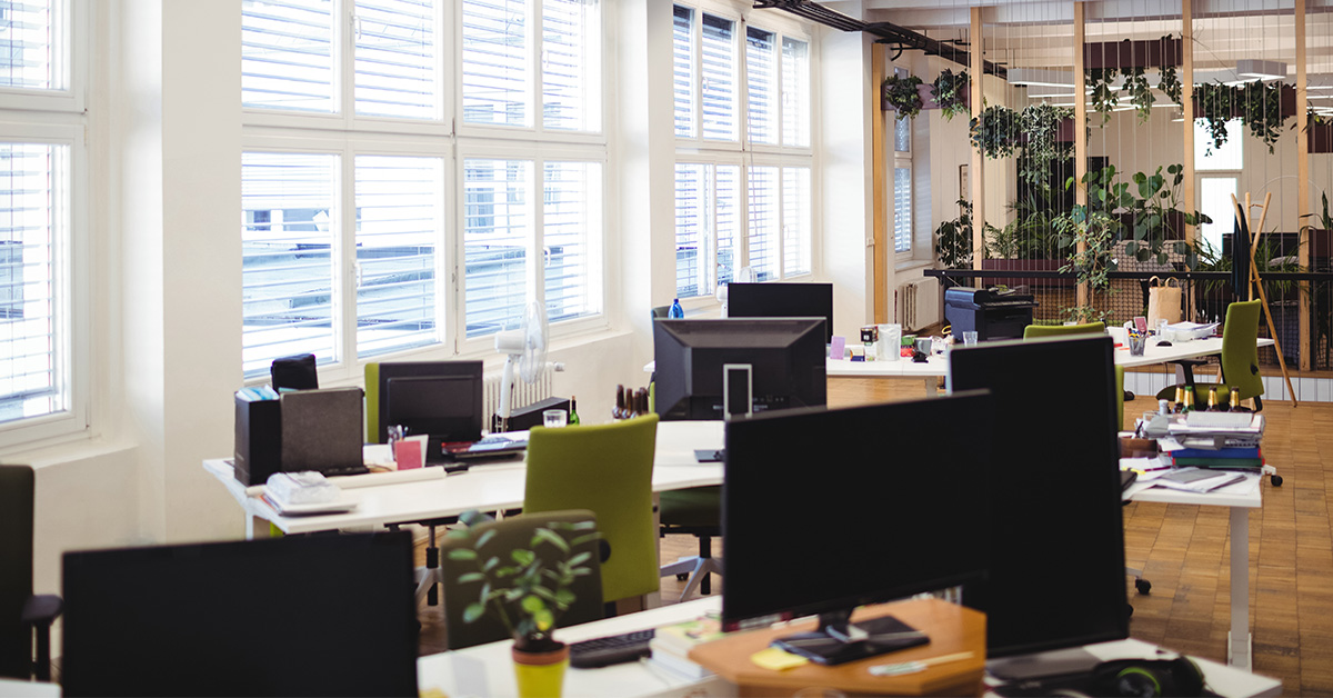 Interior of an open-air office with desks and computers. 