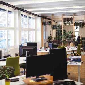 Interior of an open-air office with desks and computers.